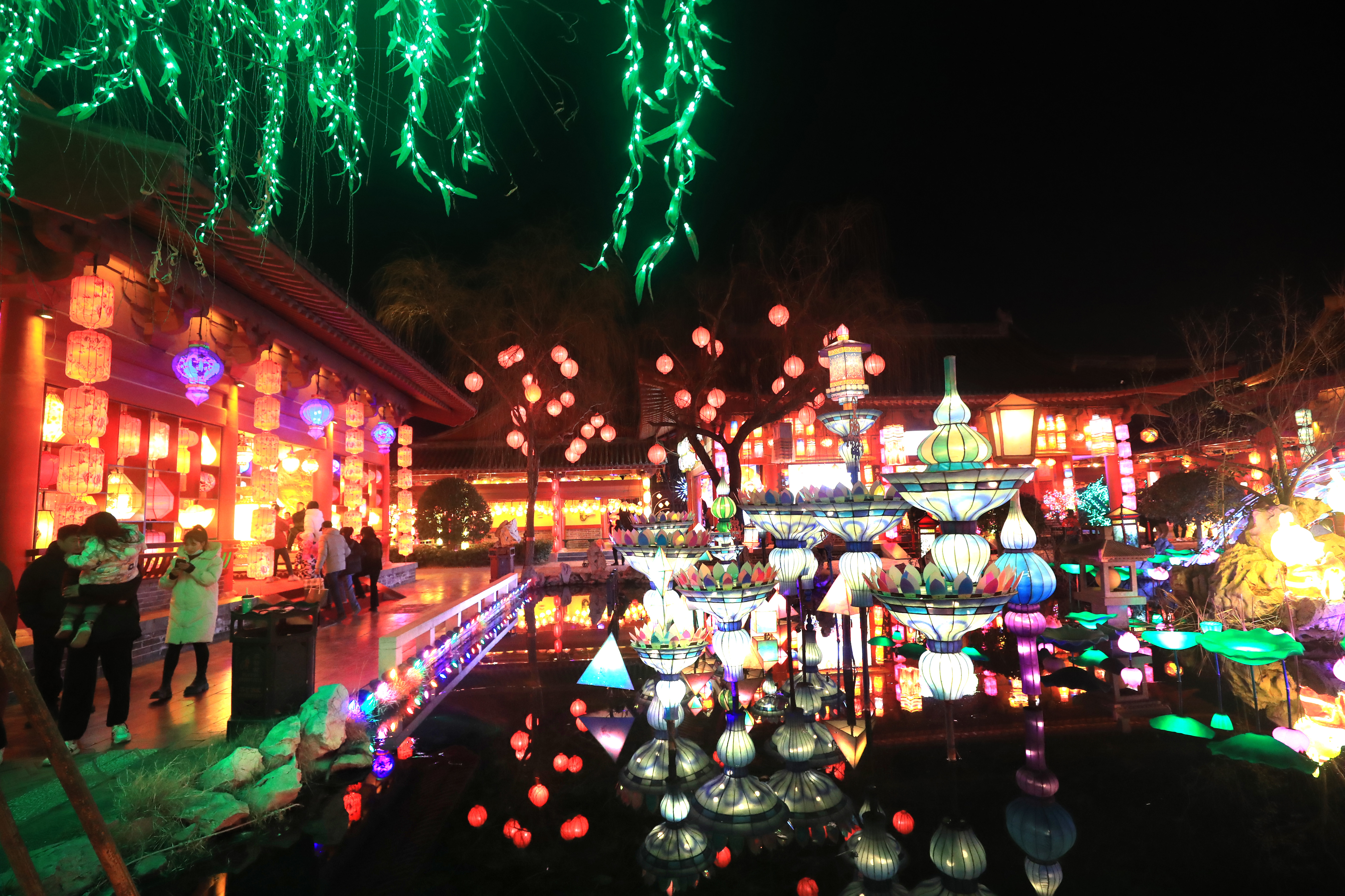 1月20日晚，游客在清明上河园观赏灯展拍照留念。春节将至，我市公园景点举办的大宋上元灯会开始亮灯，百万灯笼汇聚、万盏名灯闪烁，吸引许多游客前来观赏。全媒体记者  李俊生  摄