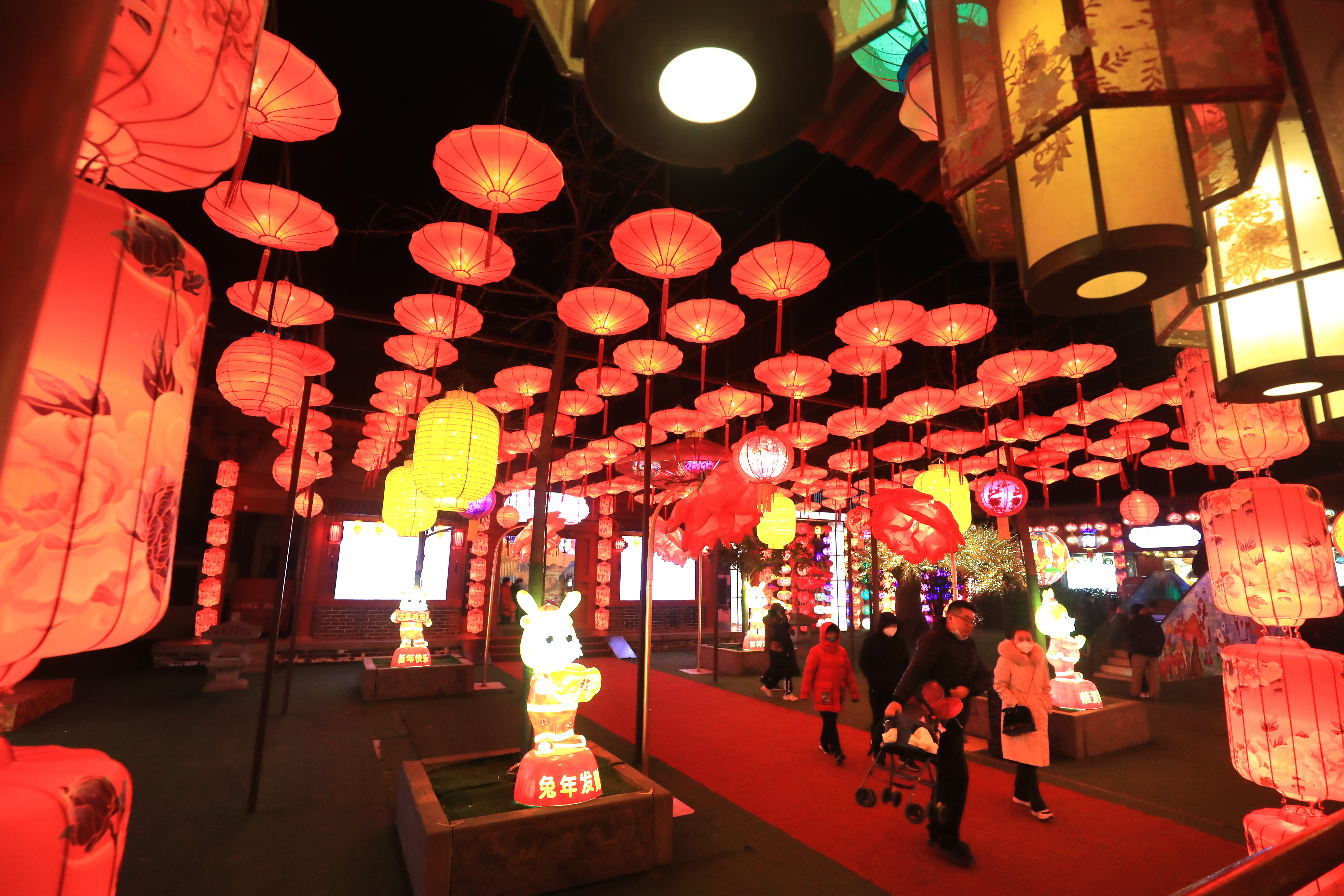 1月20日晚，游客在清明上河园观赏灯展拍照留念。春节将至，我市公园景点举办的大宋上元灯会开始亮灯，百万灯笼汇聚、万盏名灯闪烁，吸引许多游客前来观赏。全媒体记者  李俊生  摄