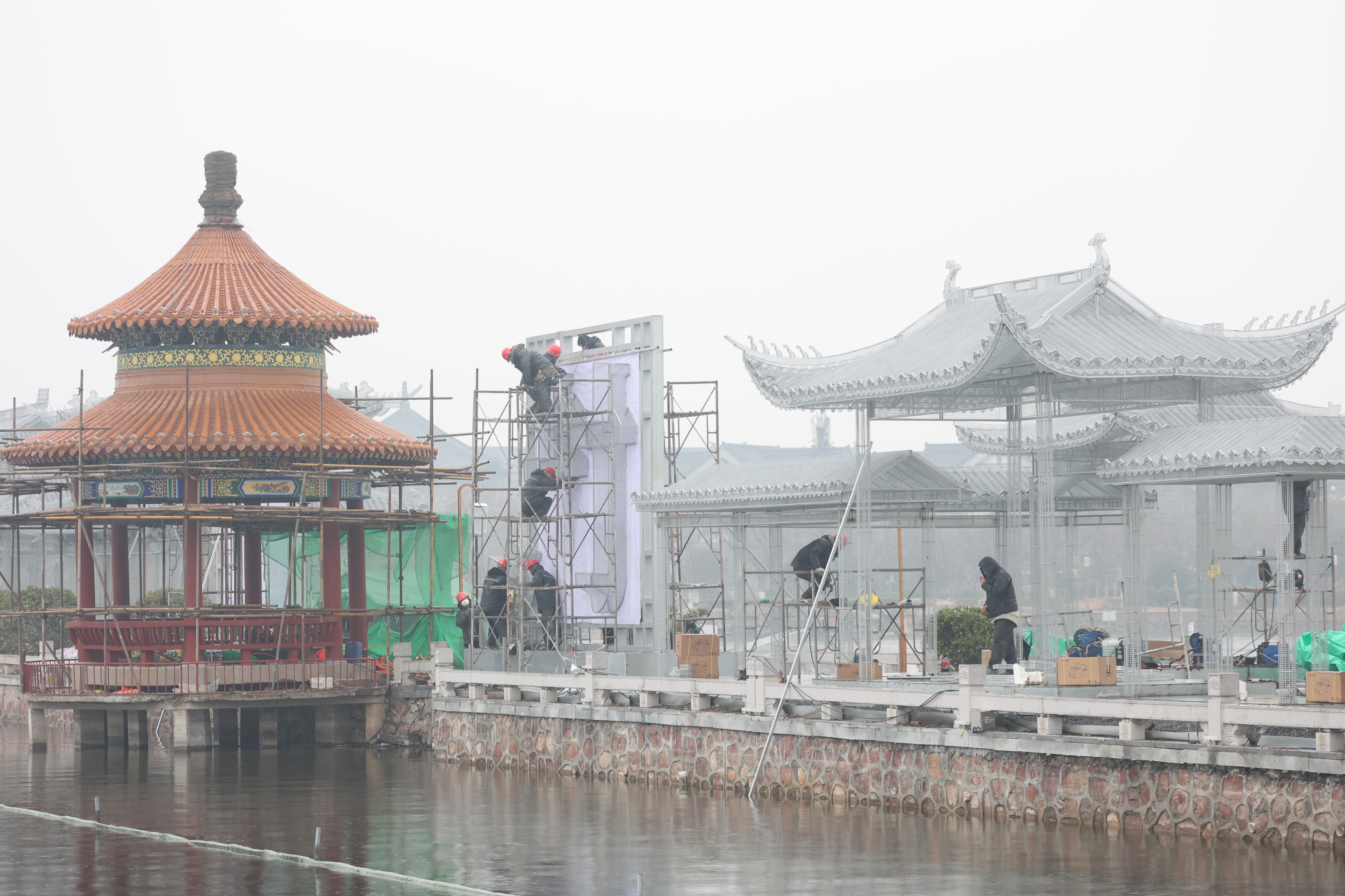1月25日，龙亭公园里施工忙，工人正在搭建新的建筑以及花灯造型景观，为游客带来一个更有视觉冲击力的景色。全媒体记者 李浩 摄