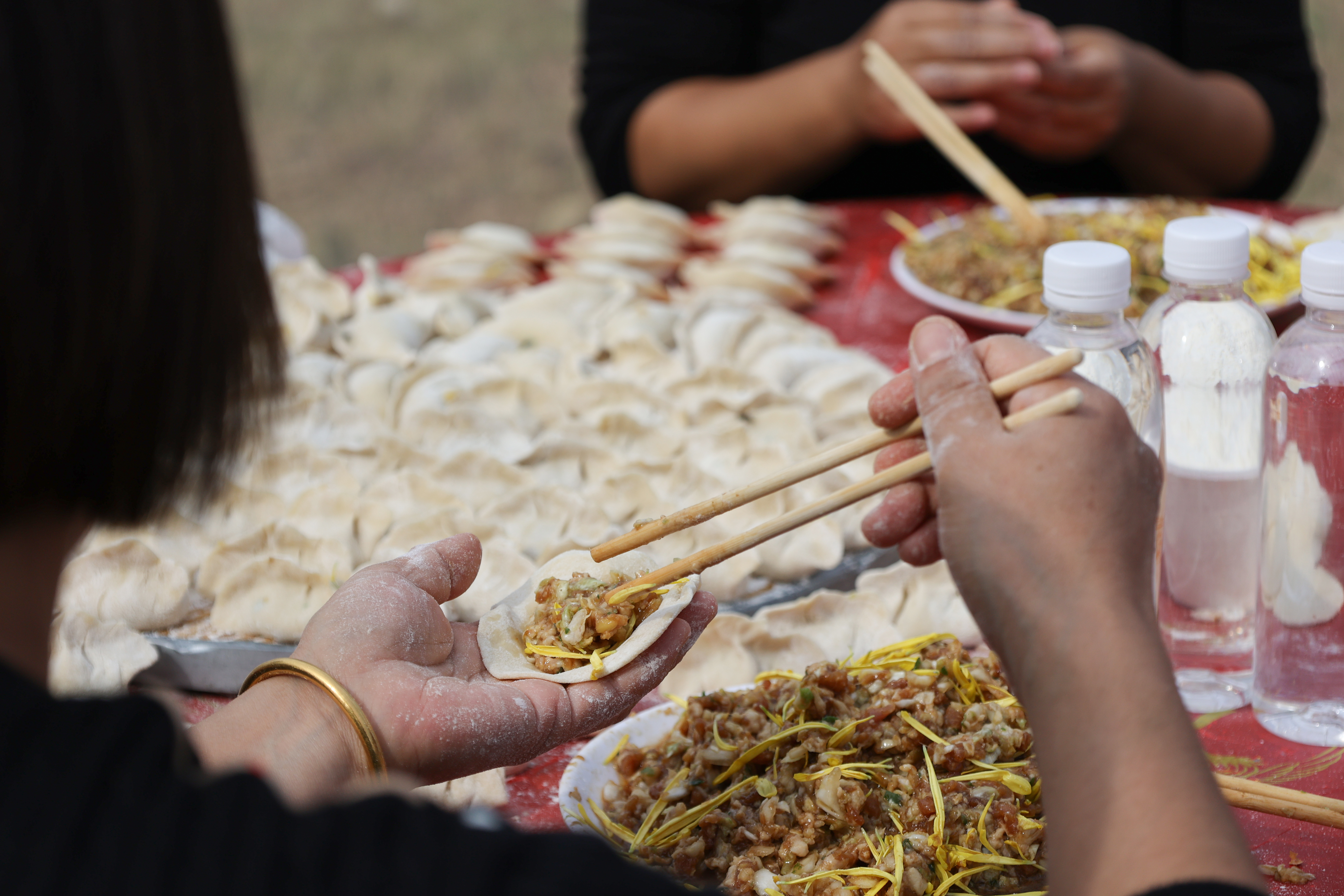 10月18日，志愿者在开封市产城融合示范区菊花千亩种植基地包饺子，陪老人过重阳。全媒体记者 石斐摄