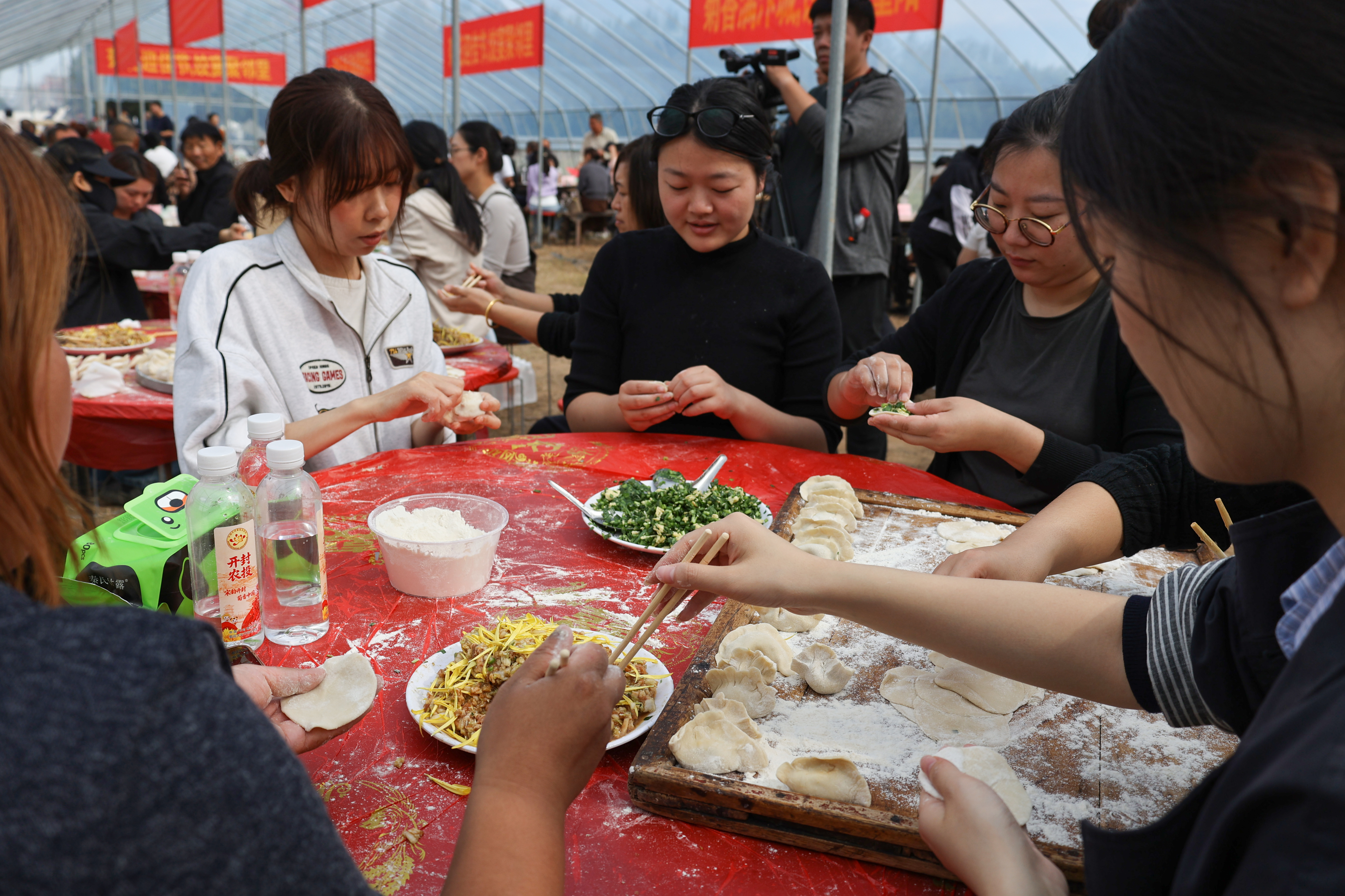 10月18日，志愿者在开封市产城融合示范区菊花千亩种植基地包饺子，陪老人过重阳。全媒体记者 石斐摄